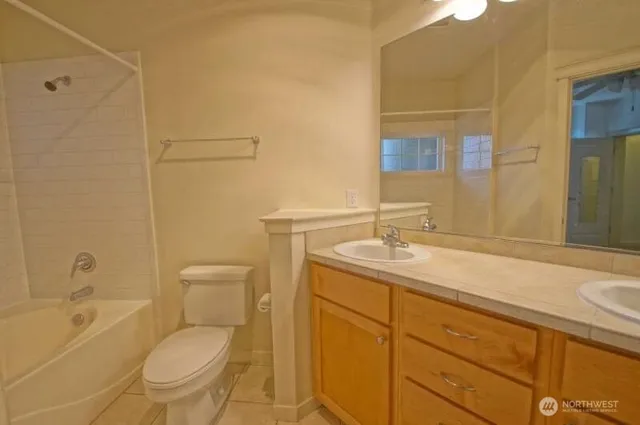 a bathroom with a granite countertop toilet a sink and a bathtub