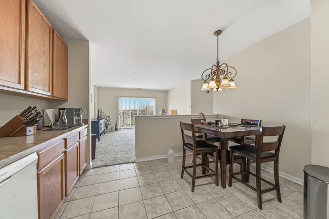 a view of a dining room and a kitchen with a chandelier
