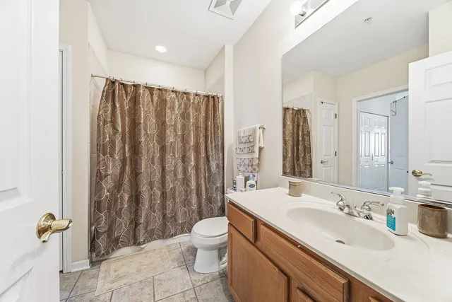 a bathroom with a double vanity sink toilet and shower