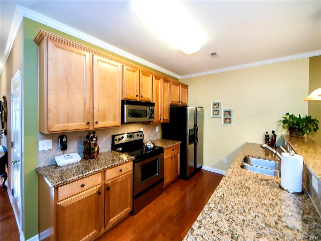 1907 Travertine Lane, Unit 209 Fort Mill, SC 29708 - Photo 7 of 18 a kitchen with stainless steel appliances granite countertop a stove a sink and a refrigerator