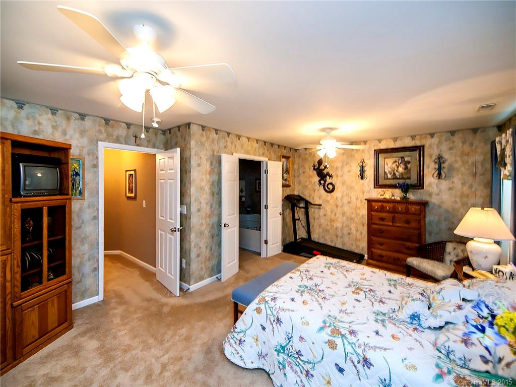 1907 Travertine Lane, Unit 209 Fort Mill, SC 29708 - Photo 10 of 18 a bedroom with a bed dresser and a flat tv screen