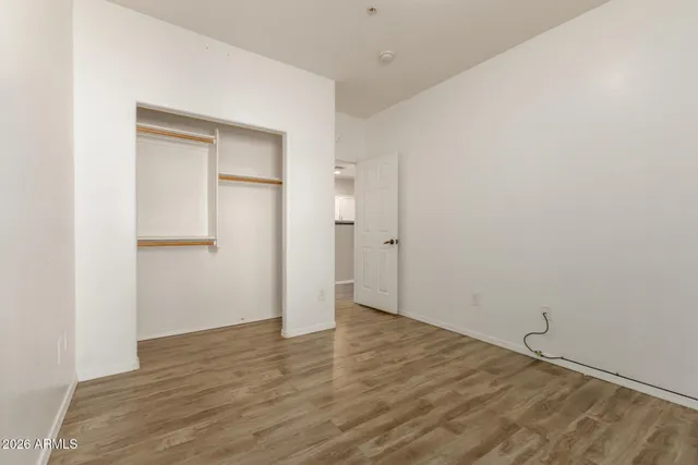 an empty room with wooden floor and closet
