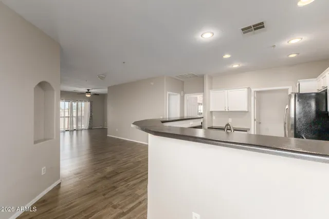 a kitchen with stainless steel appliances granite countertop a sink a stove and a refrigerator with wooden floor