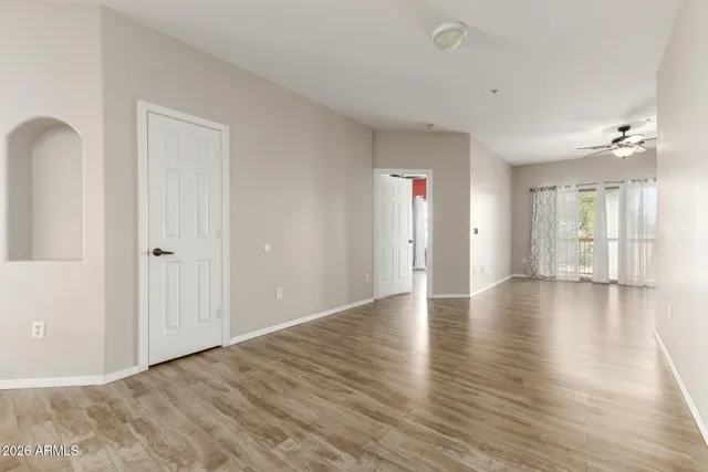 an empty room with wooden floor and windows