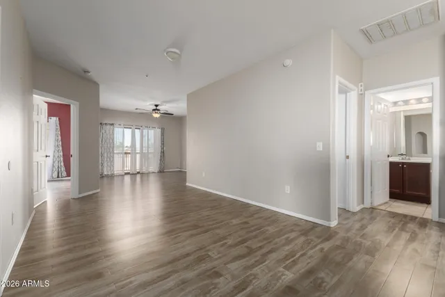 a view of a hallway with wooden floor and a bathroom