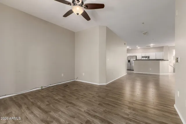 a view of a kitchen with a fridge and wooden floor