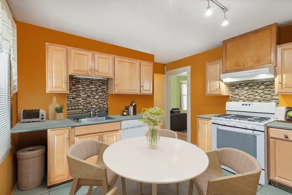 7 Vassar Street Boston, MA 02121 - Photo 3 of 8 a kitchen with a table chairs stove and cabinets