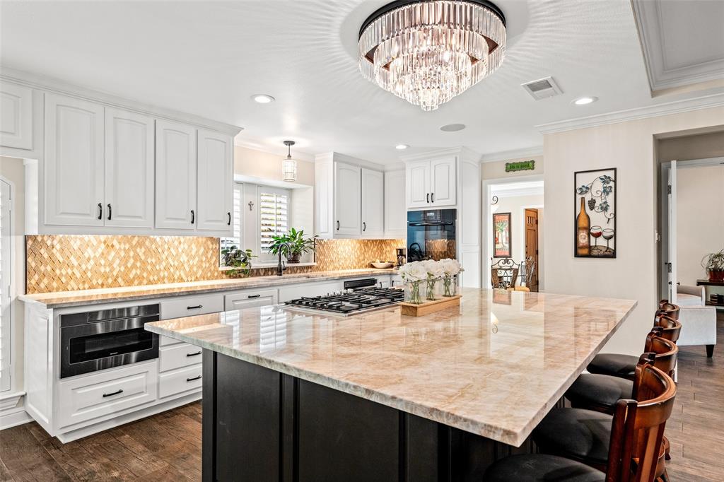 400 Hunters Ridge Circle Coppell, TX 75019 - Photo 8 of 35 a kitchen with a table chairs and stove