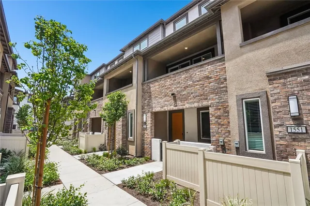 a view of a house with a large windows and flower plants
