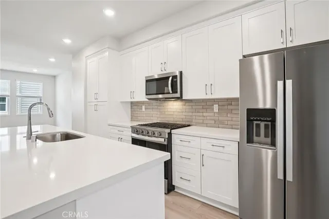 a kitchen with white cabinets and stainless steel appliances