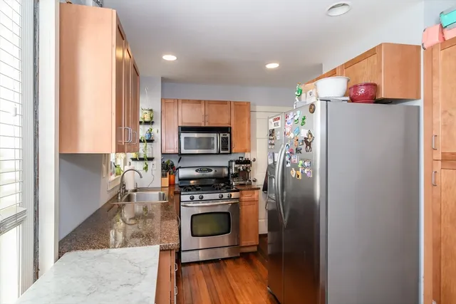 a kitchen with stainless steel appliances a stove top oven a sink and a refrigerator