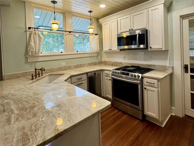 a kitchen with a stove a sink and a microwave
