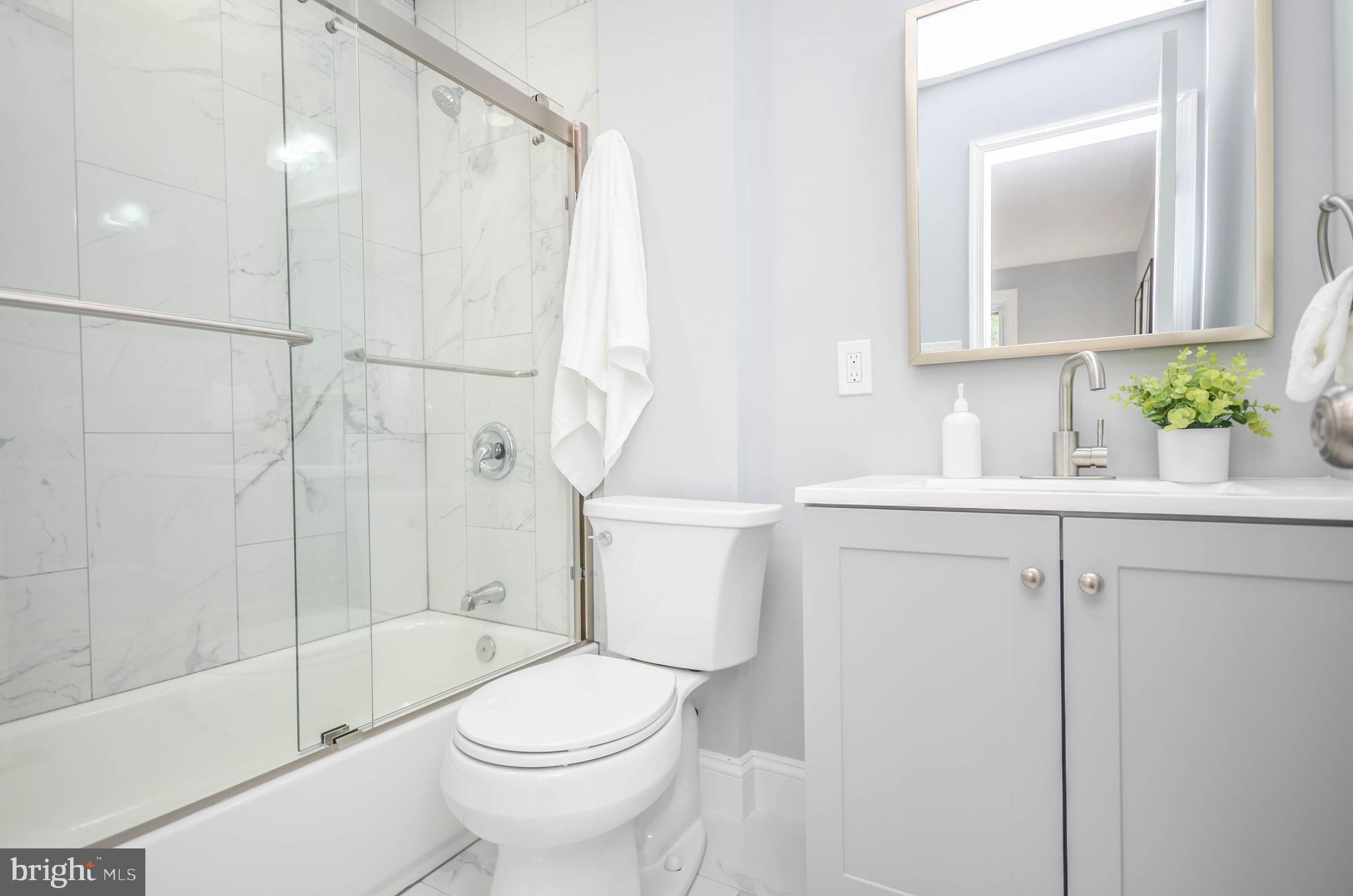 7009 Adelphi Road Hyattsville, MD 20782 - Photo 19 of 41 a bathroom with a sink a toilet and shower