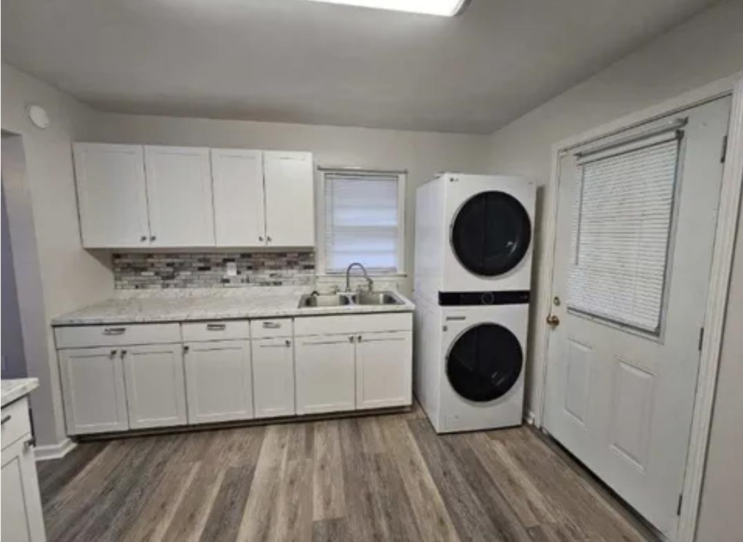 3497 Brantley Road Memphis, TN 38109 - Photo 4 of 10 Washroom with a sink, stacked washer / dryer, wood finished floors, and cabinet space