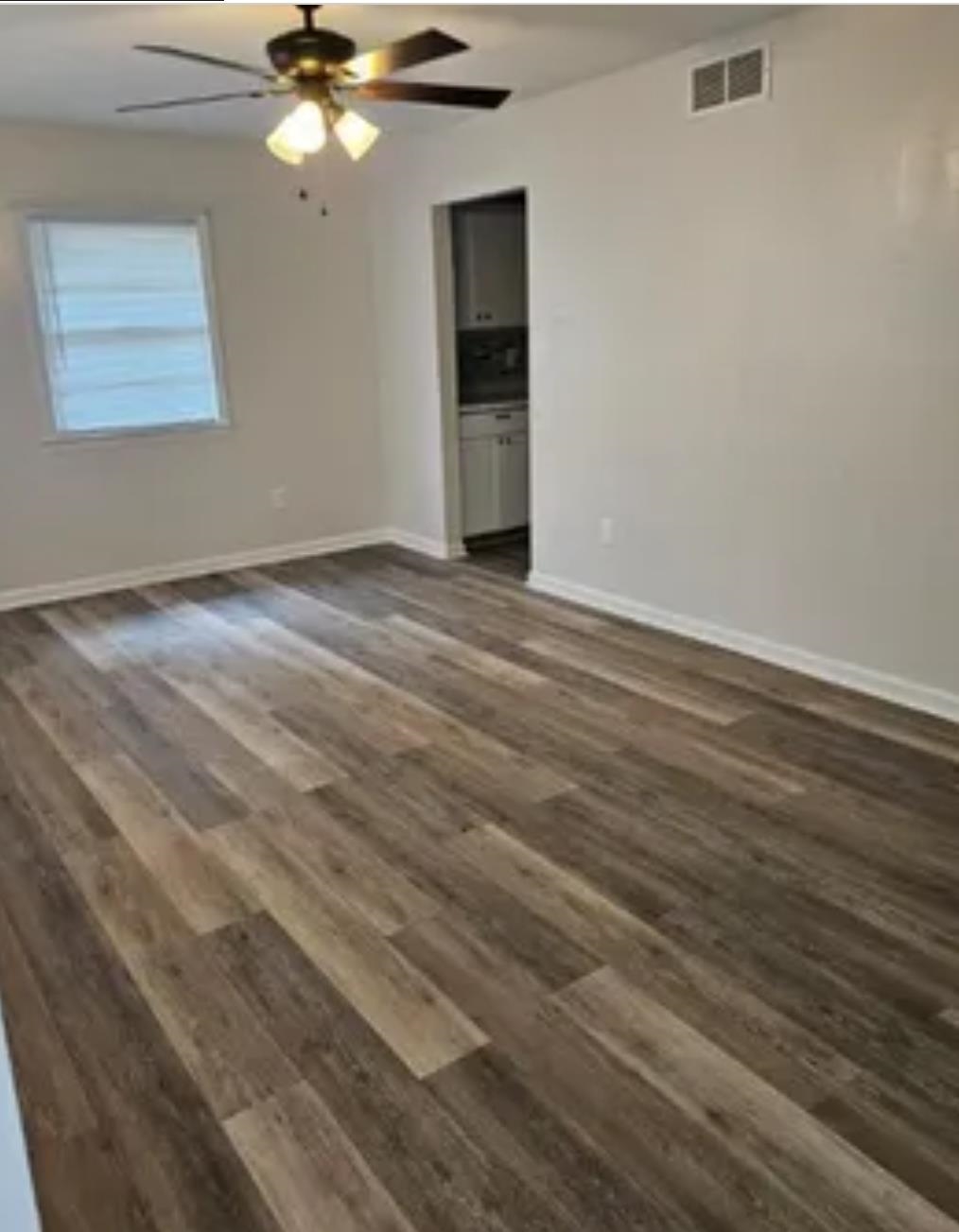 3497 Brantley Road Memphis, TN 38109 - Photo 7 of 10 Unfurnished room featuring visible vents, dark wood finished floors, baseboards, and ceiling fan