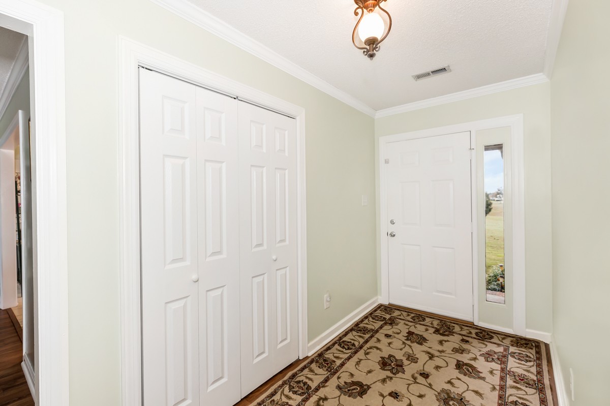 27404 Cedar Hill Road Ardmore, AL 35739 - Photo 5 of 32 a view of a hallway with wooden floor and a chandelier