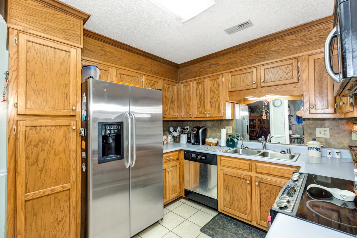 27404 Cedar Hill Road Ardmore, AL 35739 - Photo 10 of 32 a kitchen with stainless steel appliances granite countertop a refrigerator a sink and white cabinets