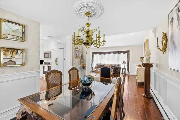 a view of a dining room with furniture a chandelier and wooden floor