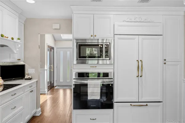 a kitchen with white cabinets and stainless steel appliances