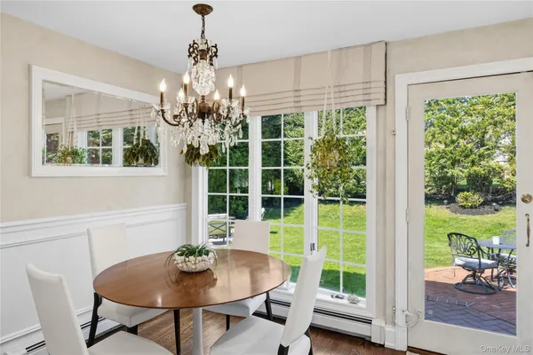 a dining room with furniture a chandelier and wooden floor