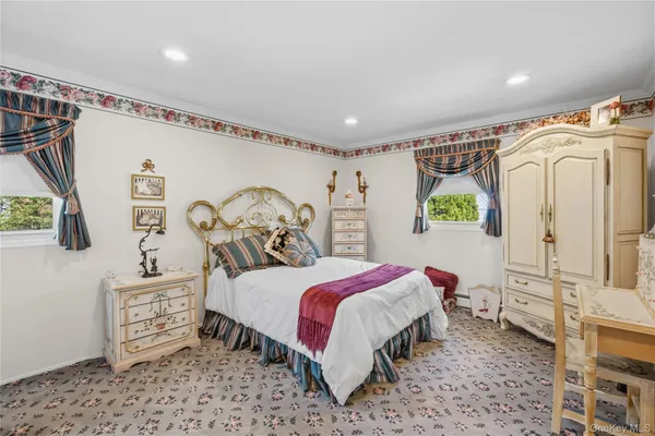 a bedroom with a bed a mirror and a window