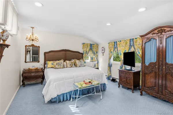 a bedroom with furniture and a flat screen tv
