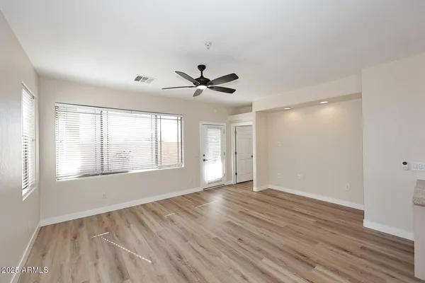 a view of an empty room with wooden floor and a window