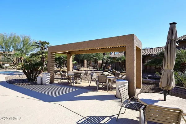 a view of a patio with table and chairs potted plants with palm trees