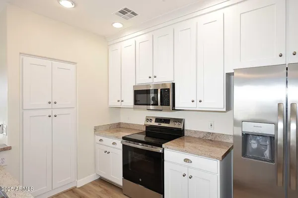 a kitchen with stainless steel appliances granite countertop a stove a sink and a refrigerator