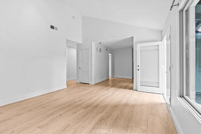 a view of an empty room with wooden floor