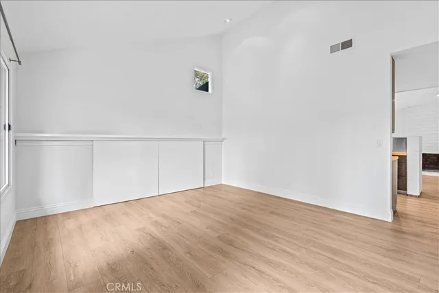 a view of an empty room with wooden floor