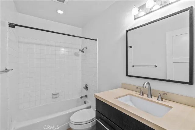 a bathroom with a sink a toilet a mirror and shower