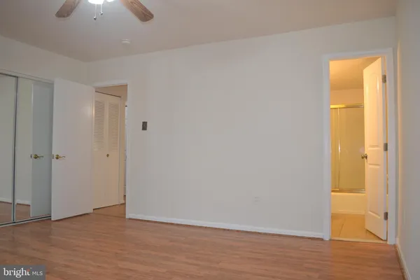 a view of empty room with wooden floor and window