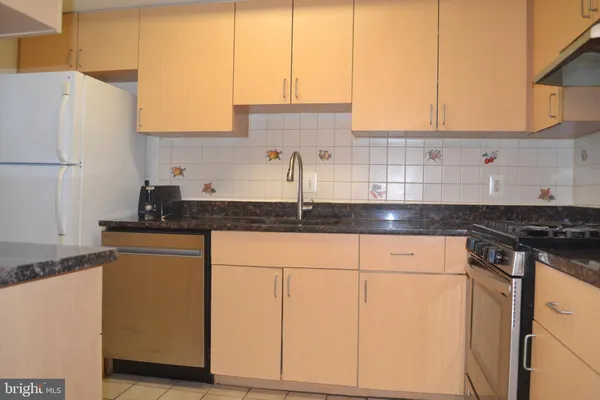 a kitchen with granite countertop white cabinets and white appliances
