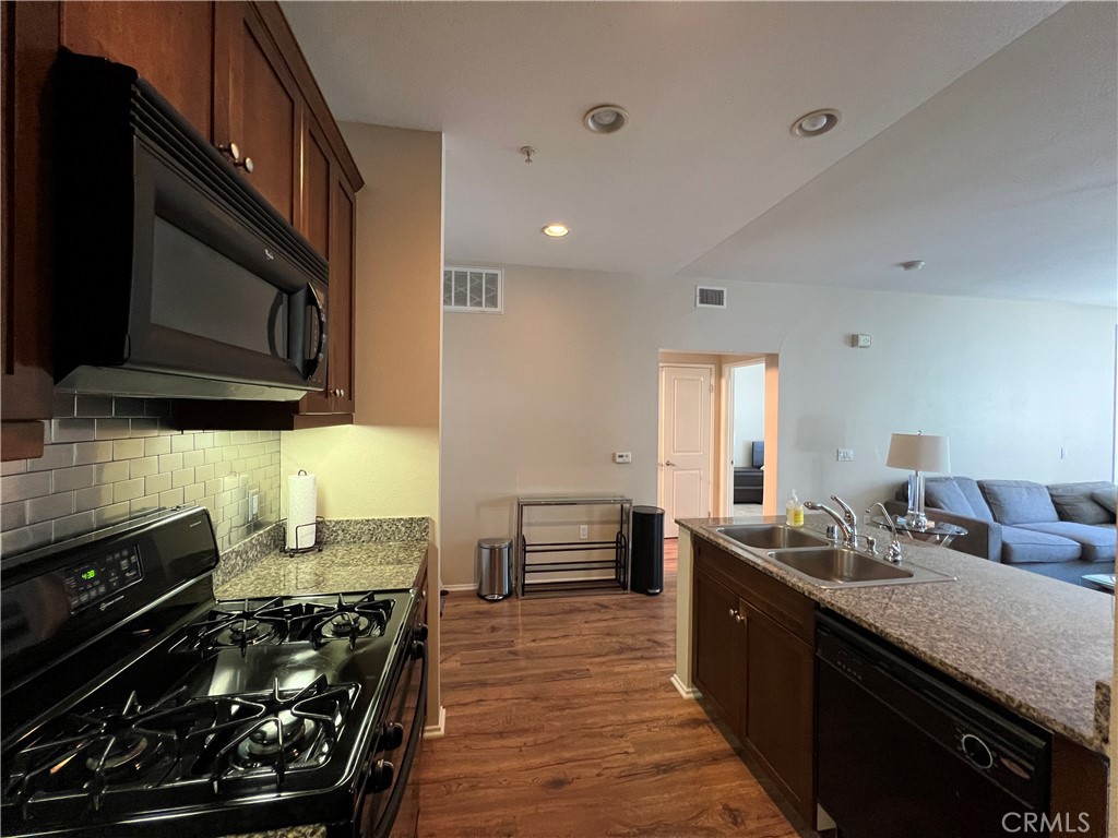 2377 Scholarship Irvine, CA 92612 - Photo 15 of 37 a kitchen with wooden cabinets and a stove top oven