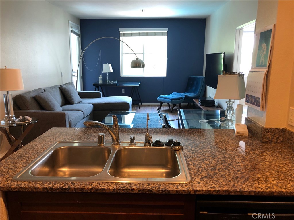 2377 Scholarship Irvine, CA 92612 - Photo 16 of 37 a kitchen with kitchen island granite countertop a sink a stove and a wooden floor