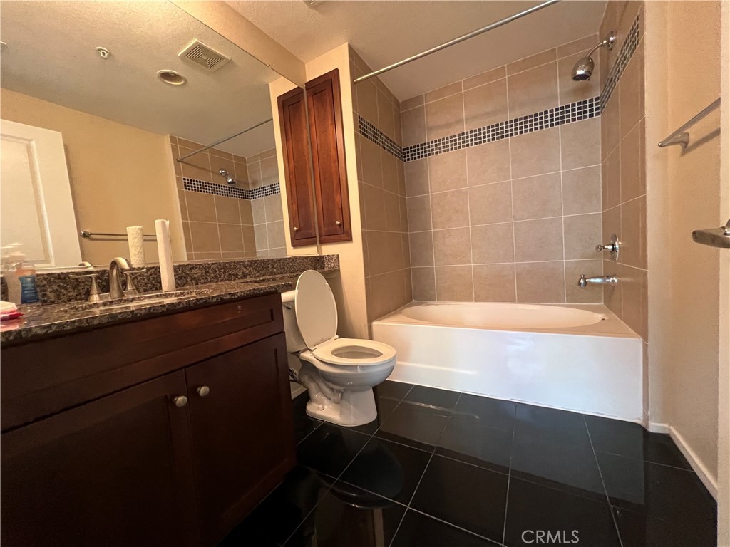 2377 Scholarship Irvine, CA 92612 - Photo 23 of 37 a bathroom with a granite countertop sink toilet a mirror and bathtub