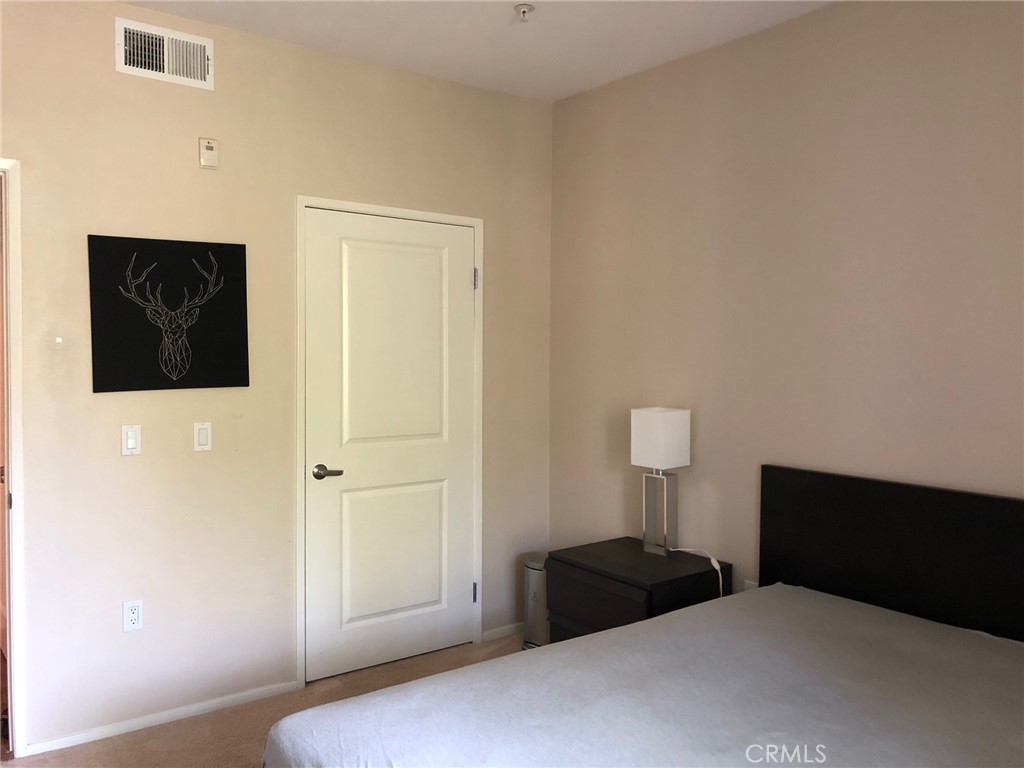 2377 Scholarship Irvine, CA 92612 - Photo 26 of 37 a bedroom with a bed and a lamp on the dresser