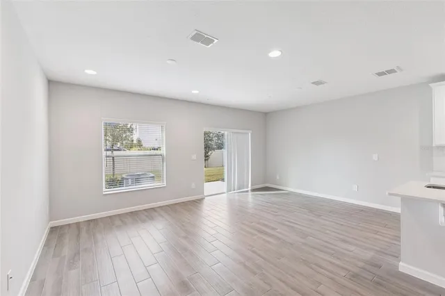 an empty room with wooden floor and a window