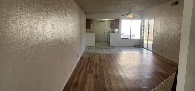 a view of a hallway with wooden floor and a window