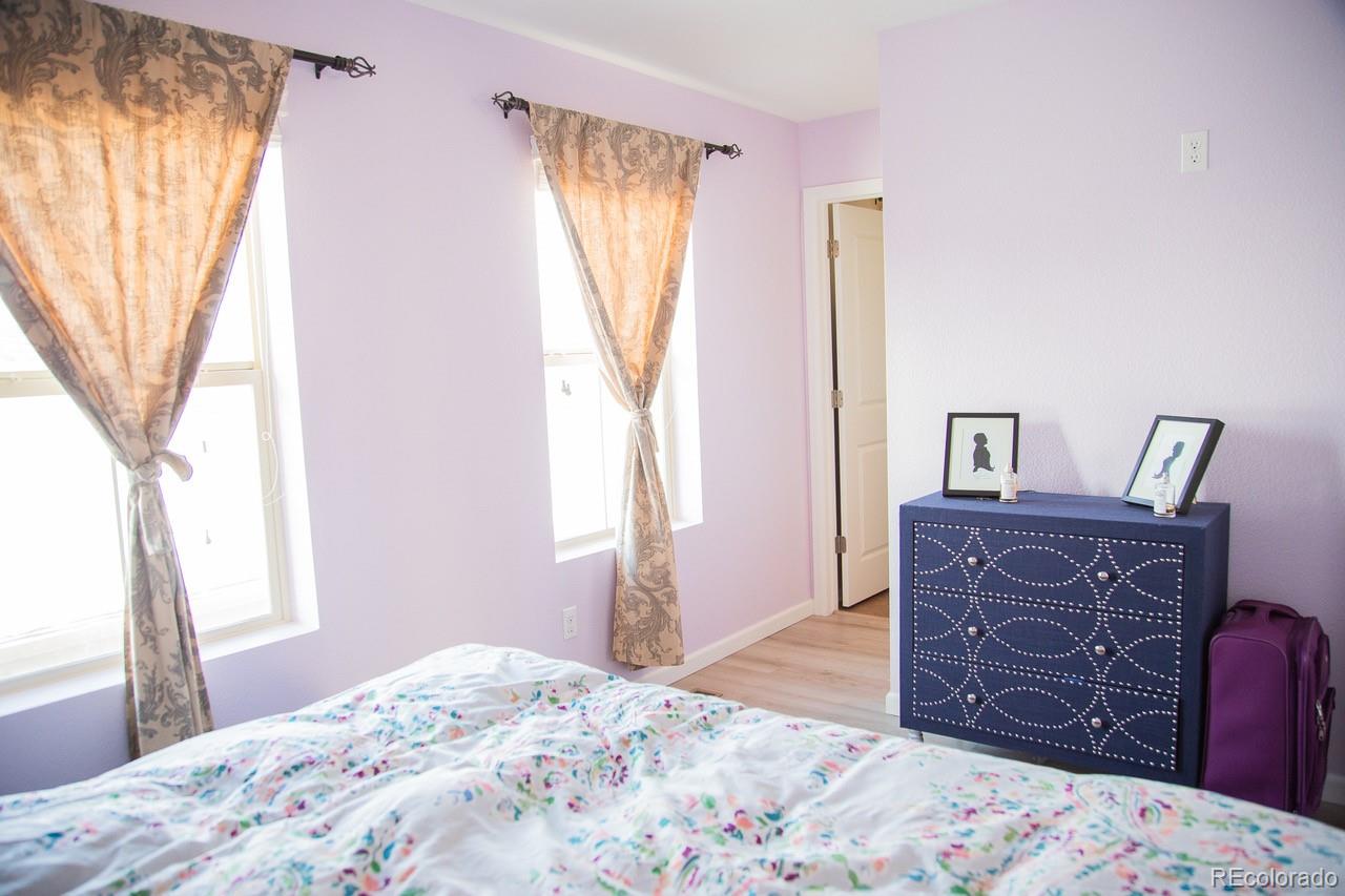 10269 Bellwether Lane Lone Tree, CO 80124 - Photo 10 of 17 a bedroom with a bed and wooden floor