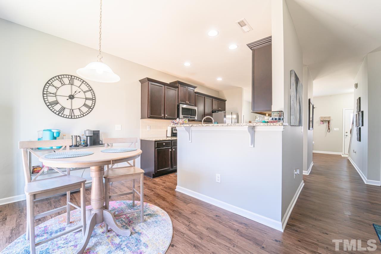 3617 Marble Ridge Lane Raleigh, NC 27610 - Photo 12 of 30 a living room with stainless steel appliances furniture a clock and a view of kitchen