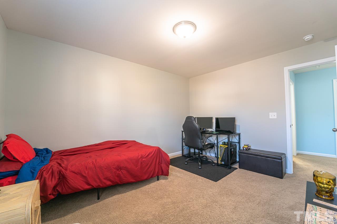 3617 Marble Ridge Lane Raleigh, NC 27610 - Photo 20 of 30 a bedroom with a bed and a chair