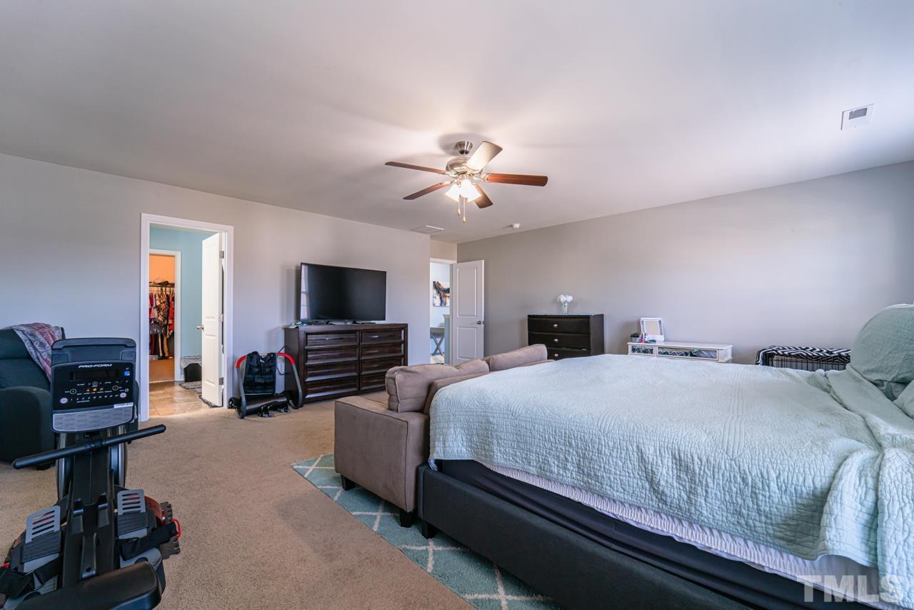 3617 Marble Ridge Lane Raleigh, NC 27610 - Photo 22 of 30 a bedroom with a bed and a flat screen tv