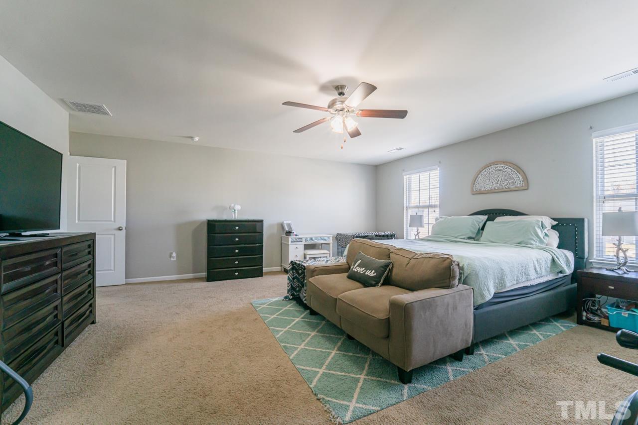 3617 Marble Ridge Lane Raleigh, NC 27610 - Photo 23 of 30 a spacious bedroom with a bed and a chandelier