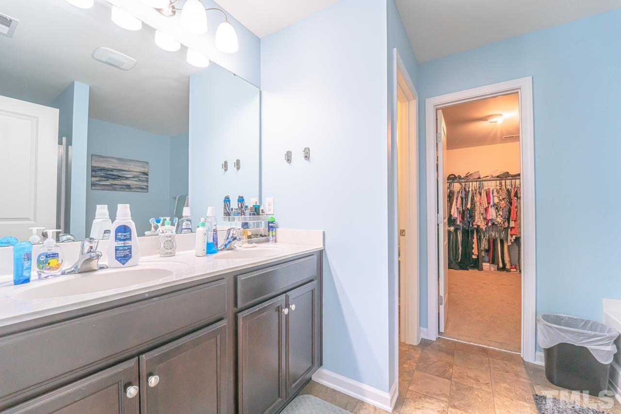 3617 Marble Ridge Lane Raleigh, NC 27610 - Photo 24 of 30 a en suite bathroom with a sink a mirror and a shower