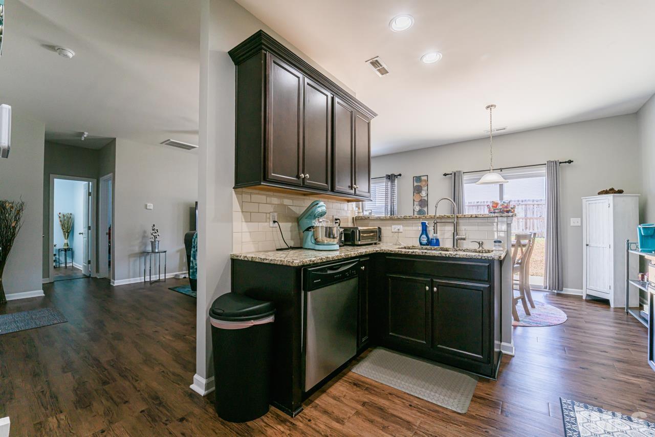 3617 Marble Ridge Lane Raleigh, NC 27610 - Photo 7 of 30 a kitchen with stainless steel appliances granite countertop a refrigerator a sink dishwasher and wooden cabinets with wooden floor