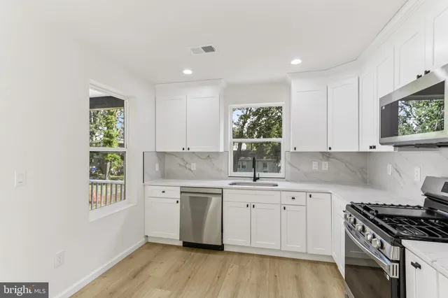 an empty room with a window and ceiling fan