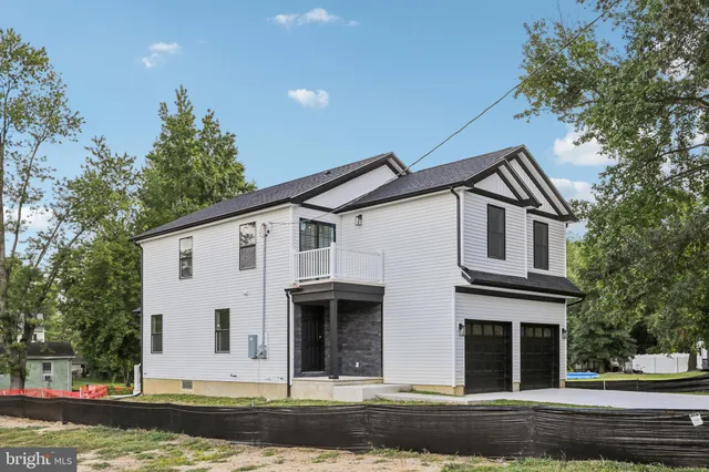 a front view of a house with a yard garage and trees