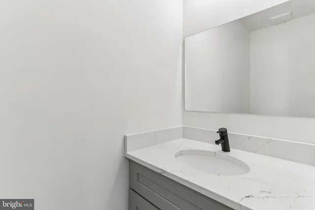 a spacious bathroom with a granite countertop toilet a sink and a mirror